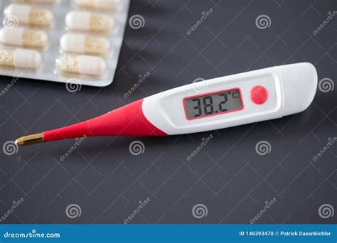 Fever Thermometer And Pills On The Desk Degrees Celsius On The