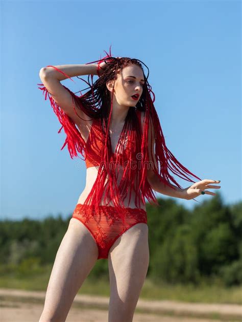Ragazza In Un Costume Da Bagno Rosso Sulla Spiaggia Immagine Stock