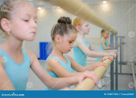 Little Girls Practicing Ballet In Studio Near Barre Concentrating On