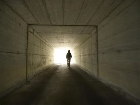 Person Walking Through Tunnel Towards Light Photographic Print
