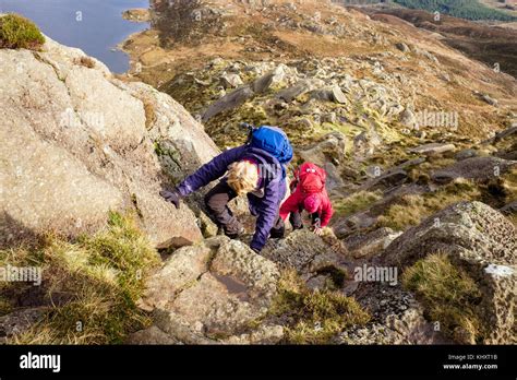Two Hikers Climbing On Daear Ddu East Ridge Rock Scramble Route On