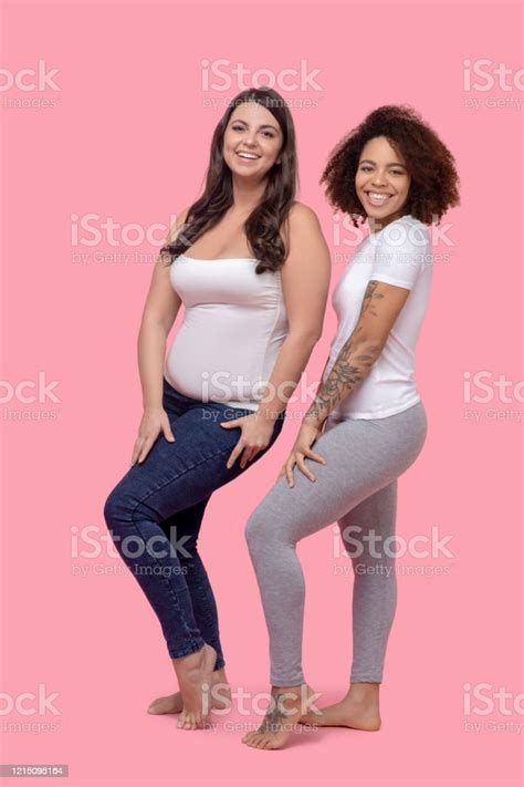 Two Girlfriend Standing Sideways In Identical Poses Barefoot Stock