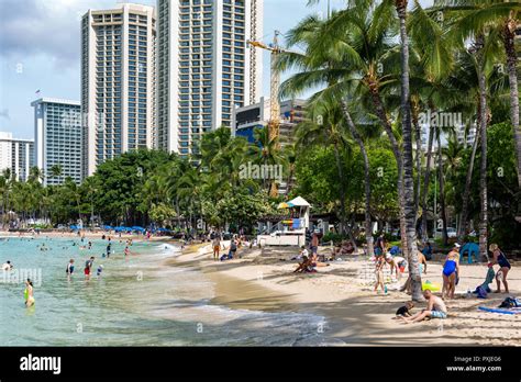 The Iconic Waikiki Beach During The Day With A Crowd Of People