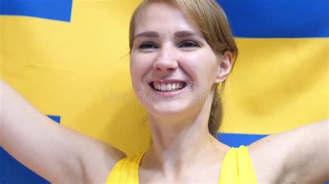 Jovem Mulher Sueco Que Comemora Ao Guardar A Bandeira Da Suécia No Movimento Lento Imagem De