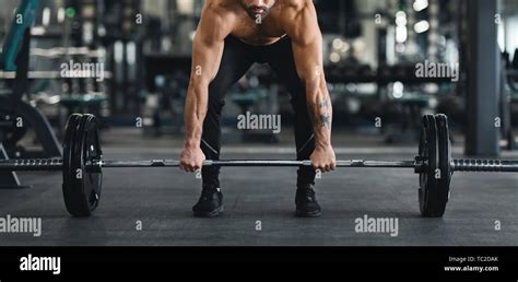 Muscular Guy Lifting Heavy Barbell From Gym Floor Stock Photo Alamy