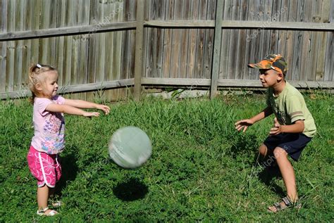 Two Kids Playing Ball In A Backyard — Stock Photo © Bolina 9819163
