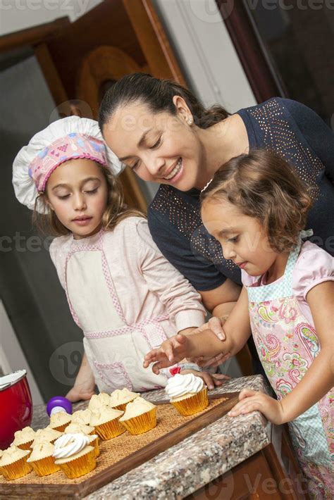 Mother And Daughters Having Fun In The Kitchen Baking Together Preparing Cupcakes With Mom