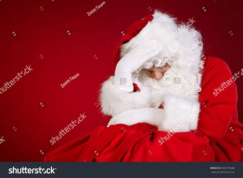 Sad Santa Claus Holding Head In Hands And Keeping Eyes Stock Photo