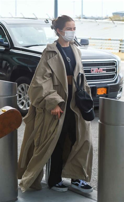 Addison Rae In A Beige Trench Coat Was Seen Out With Her Babefriend At JFK Airport In New York