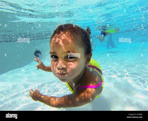 Underwater In Pool Little Girl Poses To Camera Stock Photo 137142916