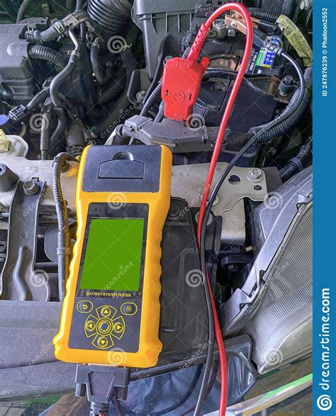 Auto Mechanics Use A Digital Battery Tester To Check The Voltage Level
