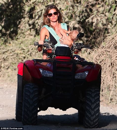 Gisele Bündchen carries her baby in one arm as she rides a quad bike on