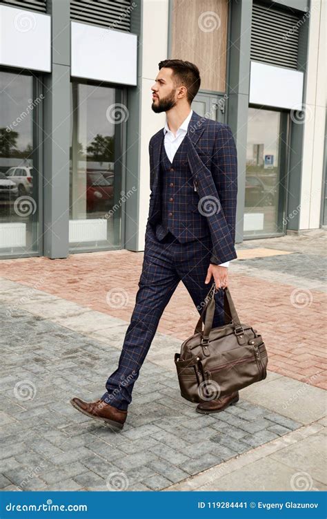 Attractive Businessman Walking Down The Street Holding Travel Bag Stock