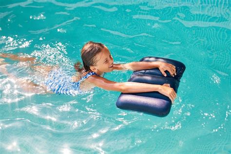 szczęśliwa dziewczynka bawi się w basenie nurkuje i pływa letnie wakacje w domu tropikalny