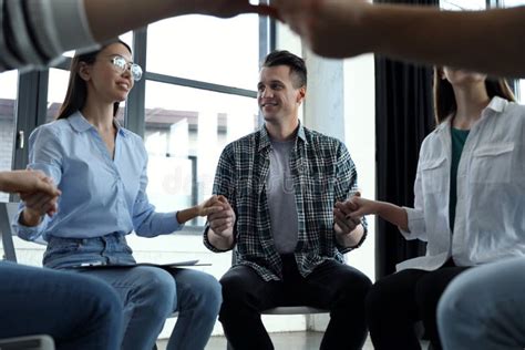 Psychotherapist Holding Hands With Patients During Group Therapy
