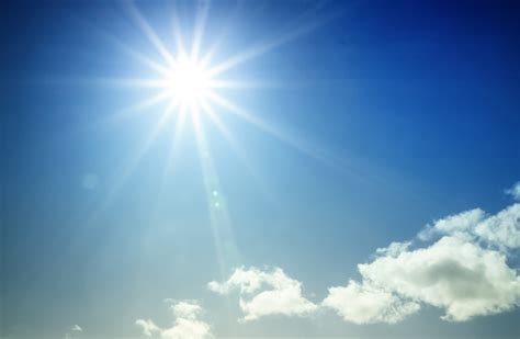 Bright Sun Shining In Blue Sky With Starburst Effect Stock Photo
