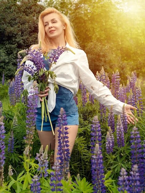 Premium Photo Woman Walks In The Garden Full Of Lupines