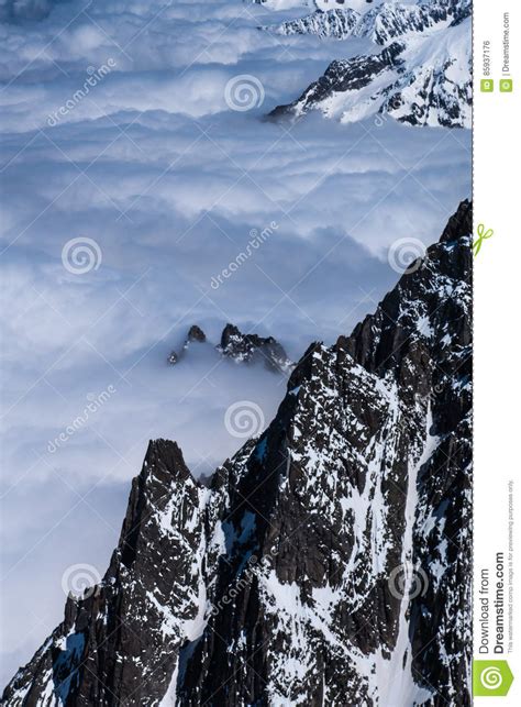 Alpine Mountain Ridges Emerging Through Cloud Cover On Top Stock Photo