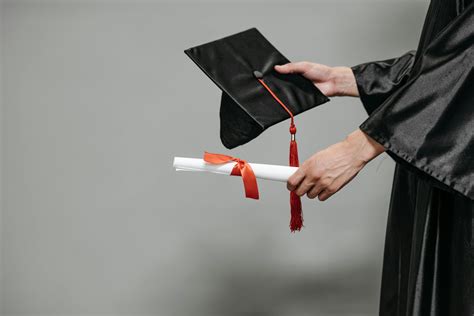 Photo Of Person Holding Graduation Cap And Diploma · Free Stock Photo
