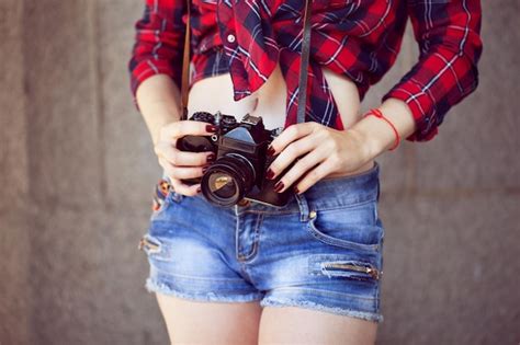 Premium Photo Girl In Shorts And A Red Shirt In A Cage With A Retro Camera In Her Hands