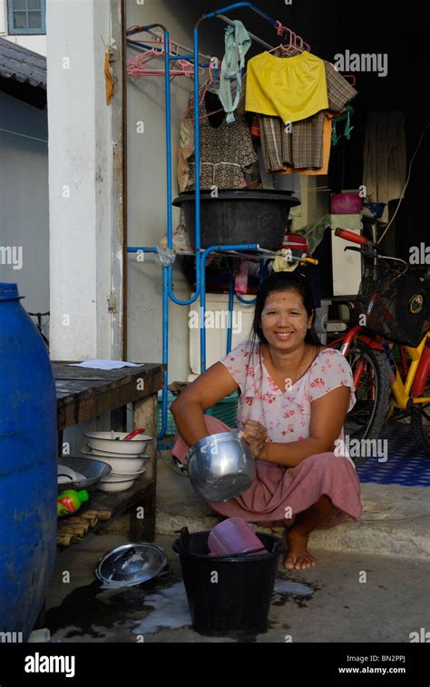 Burmese Woman Washing Dishes In Baan Nam Khen Village West Of Thailand