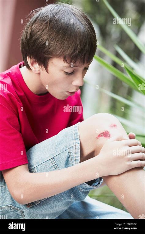 Close Up Of A Boy Holding His Wounded Knee Stock Photo Alamy