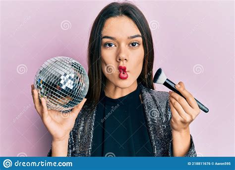 Jeune Fille Hispanique Tenant Une Boule De Disco Brillante Et Une Brosse De Maquillage Faisant