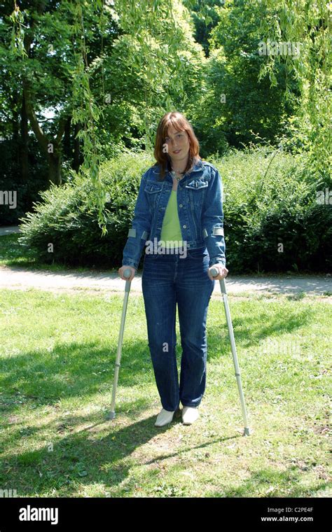 Woman On Crutches Walking In Park Stock Photo Royalty Free Image