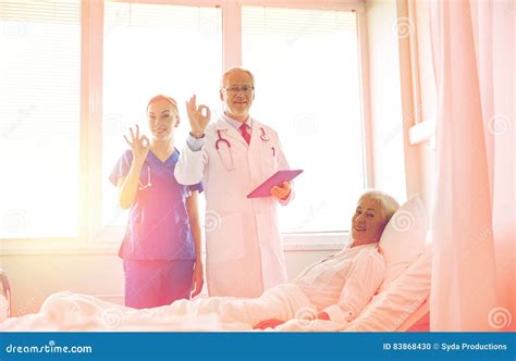 Doctor And Nurse Visiting Senior Woman At Hospital Stock Photo Image