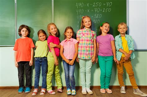 Kids Stand In Line Near The Blackboard And Smile Stock Image Image Of
