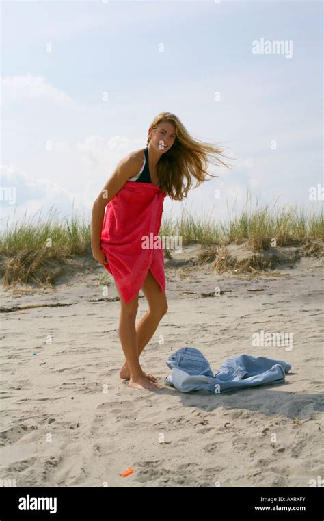 Young Blond Woman Is Changing Clothes At The Beach Stock Photo