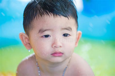 Sad Asian Kid Playing Alone In Inflatable Baby Pool Stock Image
