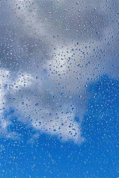 Rain Drops On Window Glasses Surface With Blue Sky And Clouds