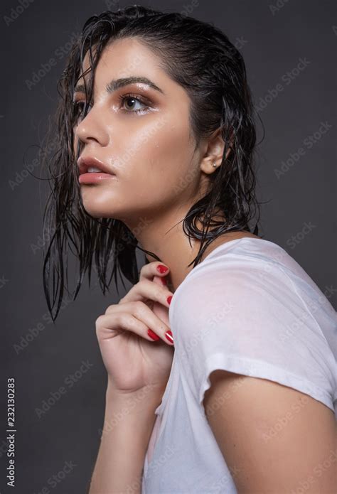 Beautiful Wet Brunette Girl With Water Drops Running Down Her Face Wearing A White Translucent