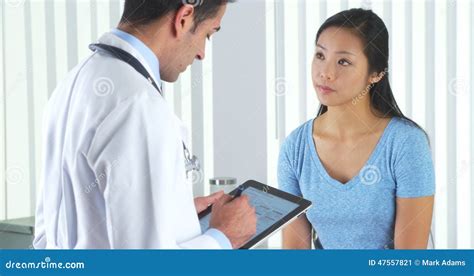 Hispanic Doctor Asking Asian Patient Questions Stock Photo Image