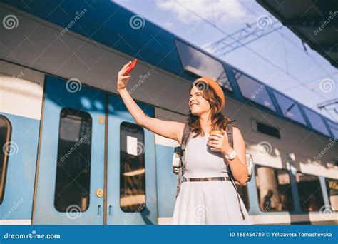 cheerful woman traveler with backpack taking photo selfie in train station travel lifestyle