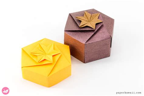 An Origami Box With A Golden Star On Top And Another One In The Background