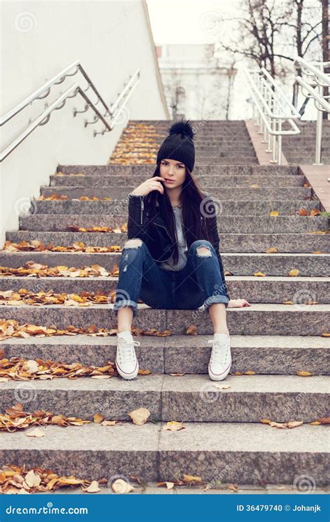 Menina Adolescente Que Senta Se Em Escadas Contra A Parede Do Grunge Foto De Stock Imagem De