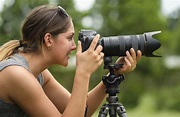 Close-up portrait of smiling woman using dslr camera outdoors ...