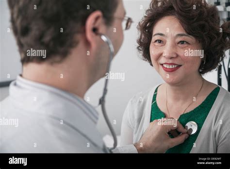 Doctor Checking Heartbeat Of A Patient With A Stethoscope Stock Photo