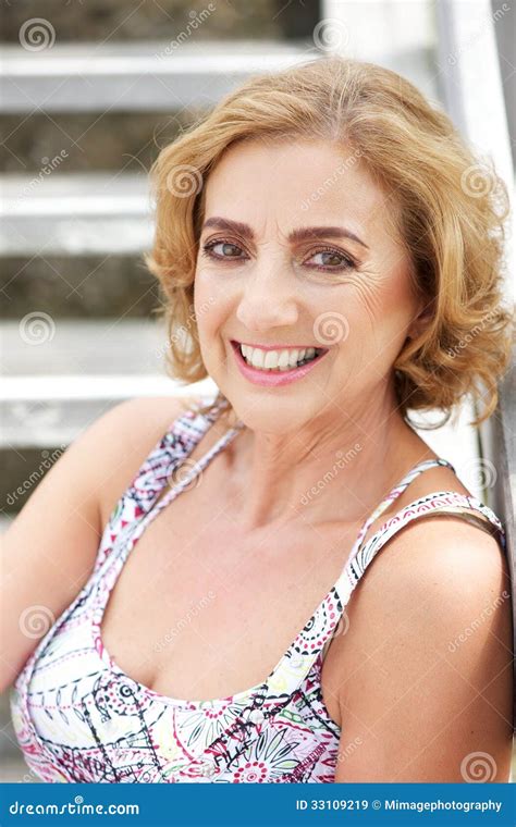 Portrait Of An Attractive Middle Aged Woman Smiling Outdoors Stock