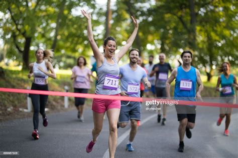 Successful Marathon Runner Crossing The Finish Line With Arms Raised
