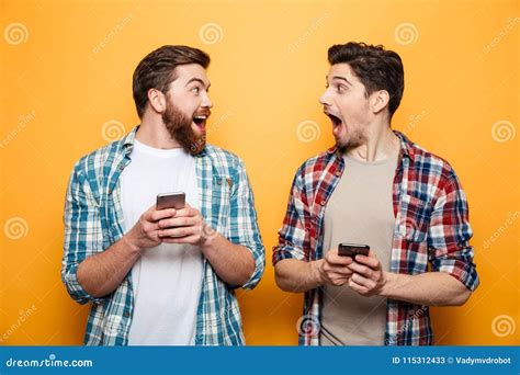 Portrait Of A Two Excited Young Men Holding Mobile Phones Stock Image