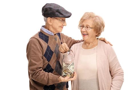coppie anziane che mettono una moneta in un barattolo dei soldi fotografia stock immagine di