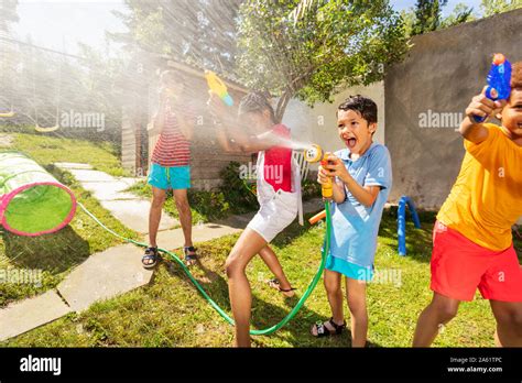 Very Happy Boy With Sprinkler In Water Gun Fight Stock Photo Alamy