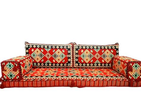 A Red Couch Sitting On Top Of A Carpet Covered Floor Next To A White Wall