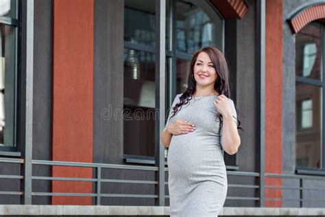 Portrait Of A Young Pregnant Woman Walking In The City Stock Photo