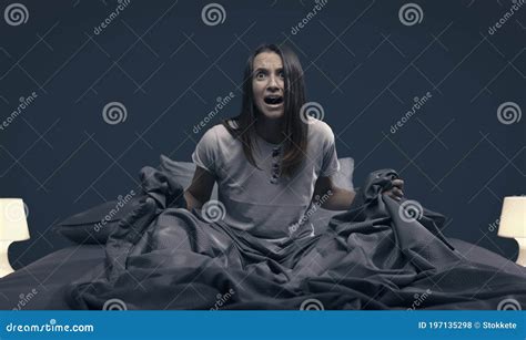 Woman Waking Up In Bed And Stopping An Alarm Clock Royalty Free Stock