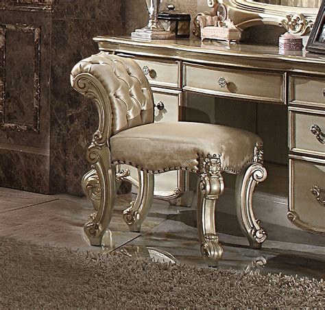 The seat and rolled back are upholstered in wool/polyester fabric, and rest on four stable, gently curved legs. Vendome Traditional Button-Tufted Beige Vanity Stool In Gold Patina