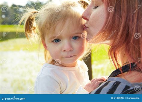 El Retrato De La Madre Y De La Hija Abraza Besarse En Parque Imagen De